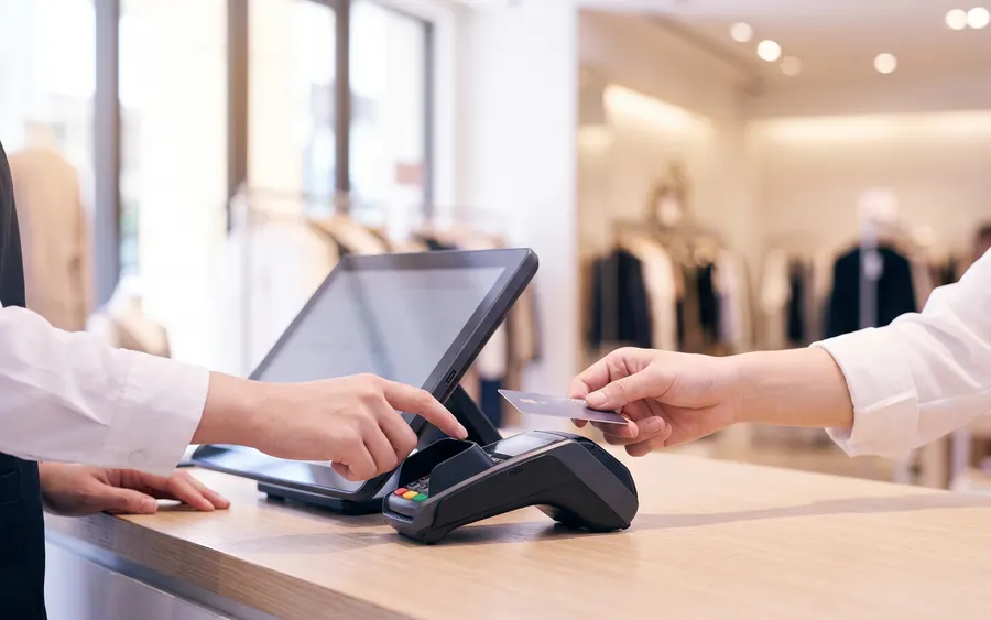 百貨專櫃收銀台以 POS 終端機完成感應式刷卡結帳，示意 FLAPS POS 銷售點系統門市交易情境